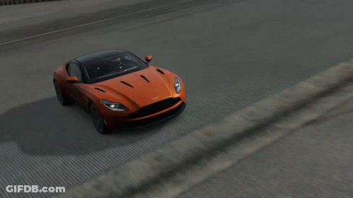 An Orange Car With A Black Roof Is Driving On A Road GIF