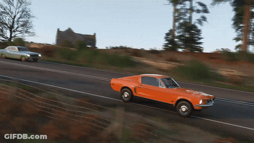 An Orange Mustang Is Driving Down A Road Next To A White Mustang GIF