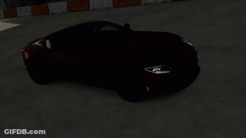 An Orange Sports Car With A Black Top Is Driving Down A Road GIF