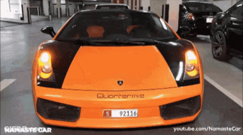 An Orange Sports Car With A License Plate That Reads 92116. GIF