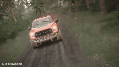 An Orange Truck Is Driving Down A Muddy Road GIF