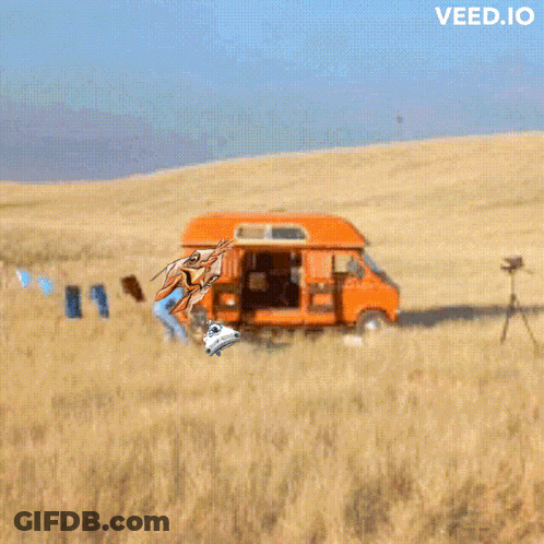 An Orange Van Is Parked In The Middle Of A Field With The Words Veed.io Above It GIF
