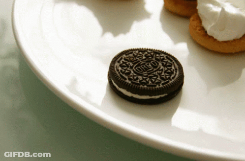 An Oreo Cookie Sits On A White Plate With Other Cookies GIF