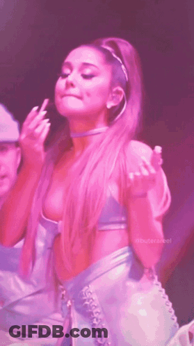 Ariana Grande Is Giving The Middle Finger While Wearing A Pink Top And Skirt GIF