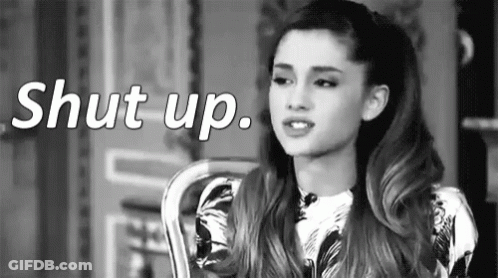 Ariana Grande Is Sitting In A Chair With The Words `` Shut Up '' Behind Her . GIF