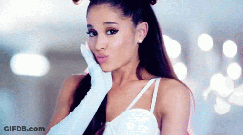 Ariana Grande Is Wearing A White Dress And White Gloves While Blowing A Kiss . GIF