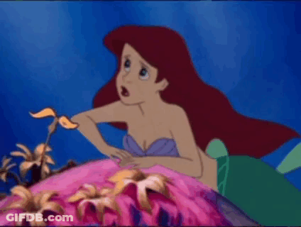 Ariel From The Little Mermaid Is Sitting On A Rock In The Ocean . GIF