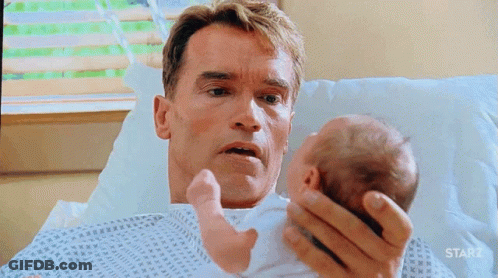 Arnold Schwarzenegger Holding Baby In Hospital Bed With Starz GIF