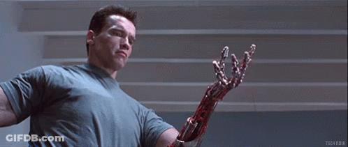 Arnold Schwarzenegger Is Holding A Bloody Robotic Arm In Terminator 2 Judgment Day . GIF