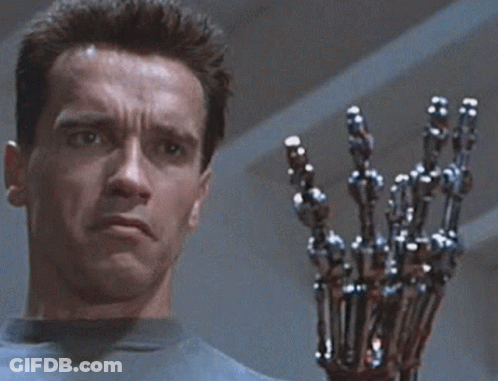 Arnold Schwarzenegger Is Holding A Robotic Arm In Front Of His Face GIF