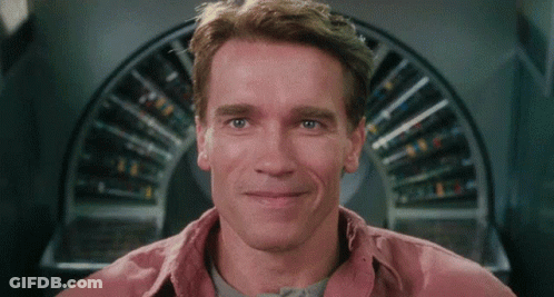Arnold Schwarzenegger Smiling In Front Of Circular Object GIF