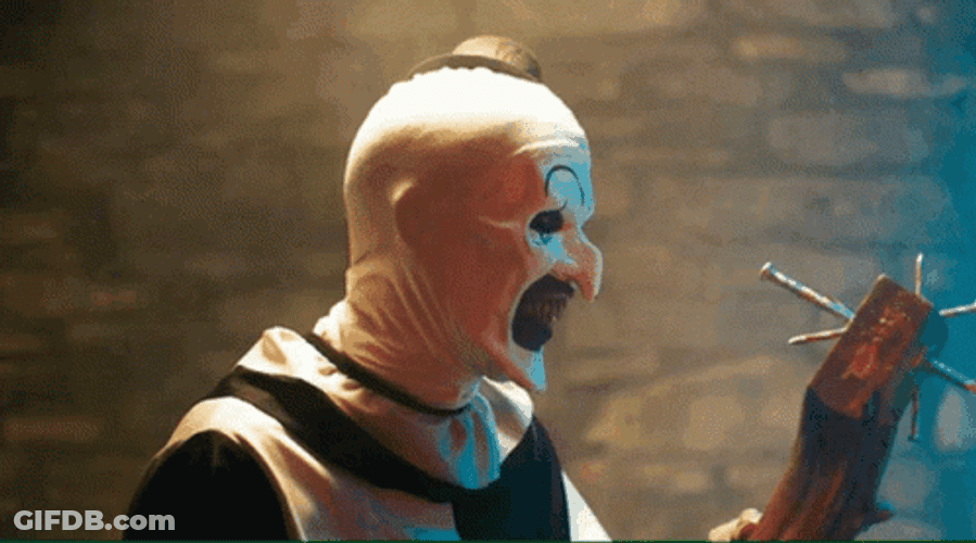 Art The Clown Looks At Wood With Nails GIF