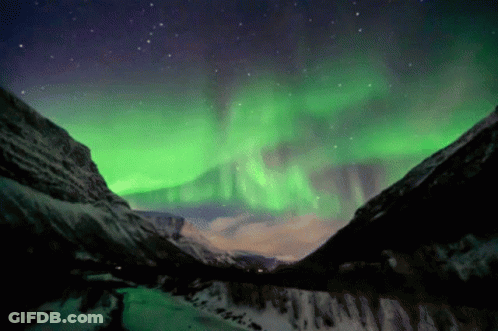 Aurora Borealis Over Snowy Mountains GIF