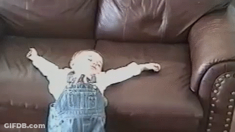 Baby Arms Outstretched On Brown Leather Couch GIF