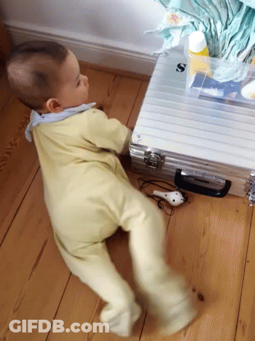 Baby Crawling Next To Briefcase With Letter S GIF