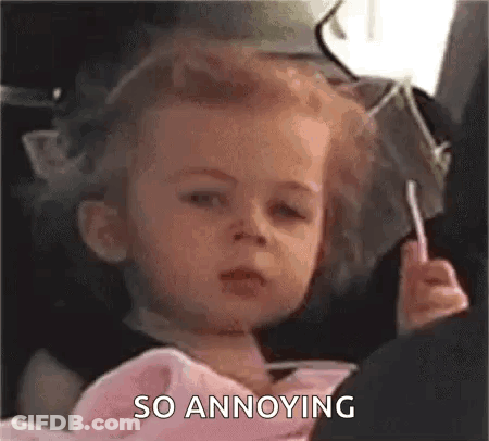 Baby Girl Makes Funny Face With Lollipop In Car Seat GIF