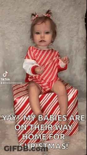 Baby Girl Sitting On Candy Cane Gift GIF