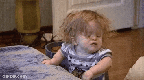 Baby Girl Sitting On Couch Making Funny Face GIF