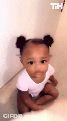 Baby Girl Sitting On Floor Looking Up At Camera GIF