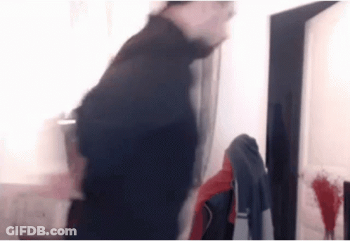 Baby Girl Standing By Wooden Table Looking At Camera GIF