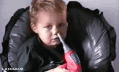 Baby Holding Toy Drill In Mouth In High Chair GIF
