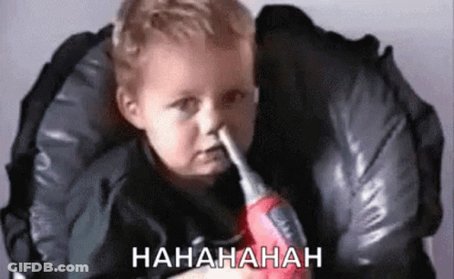 Baby Holding Toy Screwdriver In Nose In High Chair GIF
