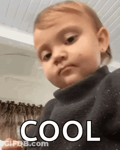 Baby In Black Sweater Making Funny Face Saying Cool GIF