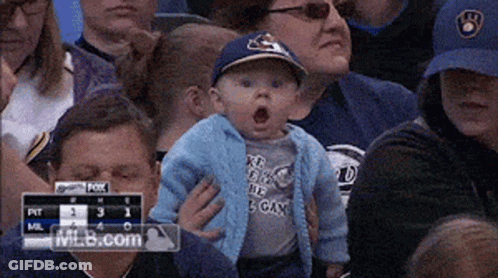Baby In Blue Brewers Hat Held By Woman GIF