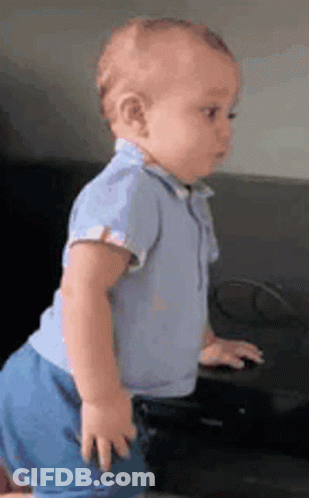 Baby In Blue Outfit By Black Couch GIF