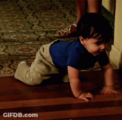Baby In Blue Shirt Crawling On Wooden Floor GIF