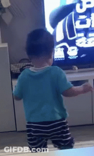 Baby In Blue Shirt In Front Of TV With Number 5 GIF