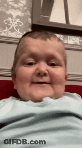 Baby In Blue Shirt Making Funny Face GIF