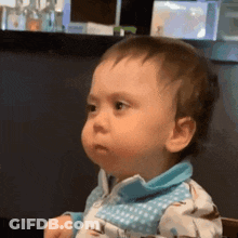 Baby In Blue Shirt Sitting In Chair Making Funny Face GIF
