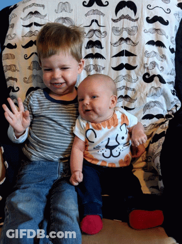 Baby In Cat Shirt Next To Boy GIF