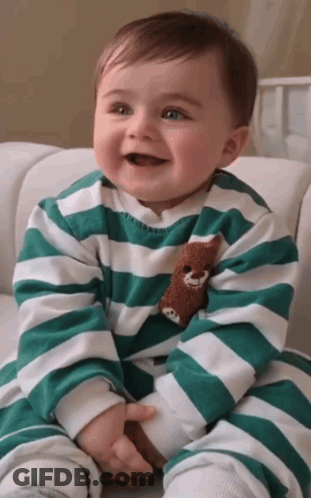Baby In Green And White Striped Shirt Holding Teddy Bear GIF