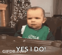 Baby In Green Bib Sitting In Chair GIF
