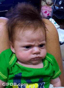 Baby In Green Shirt Making A Face GIF