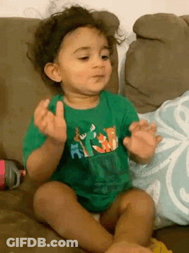 Baby In Green Shirt Making Funny Face GIF