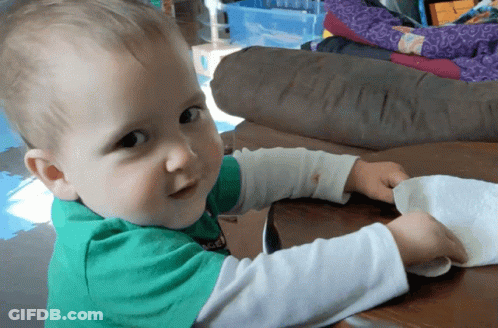Baby In Green Soccer Shirt Playing With Paper Towel GIF