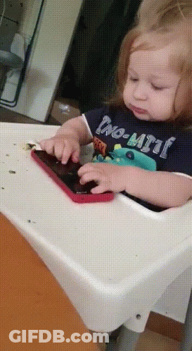 Baby In High Chair Playing With Phone Wearing No-Limit Shirt GIF
