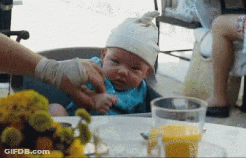 Baby In High Chair Wearing White Hat GIF