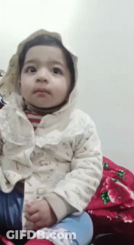 Baby In Hooded Jacket Sitting On Red Blanket GIF