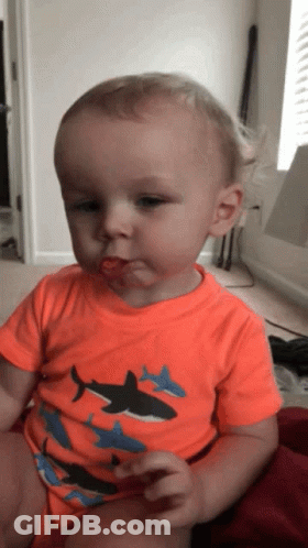 Baby In Orange Shark Shirt Eating GIF