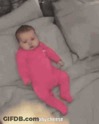 Baby In Pink Outfit Laying On Bed Baby Cheese GIF