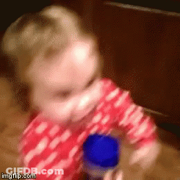 Baby In Red And White Polka Dot Shirt Playing With Blue Bottle GIF