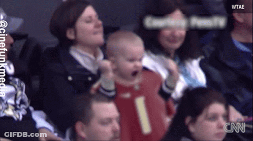 Baby In Red Jersey Number 1 Held By Woman GIF