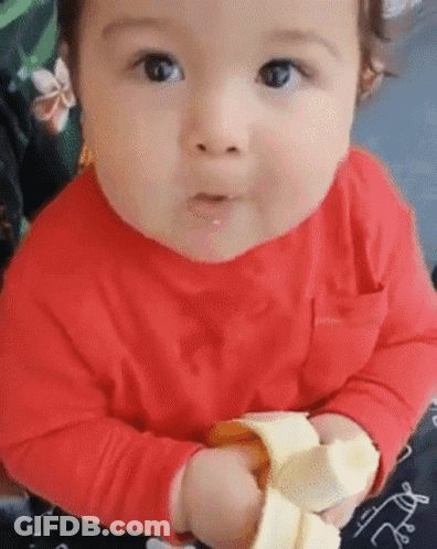 Baby In Red Shirt Eating Banana Peel GIF