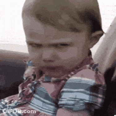Baby In Striped Shirt Making Face GIF