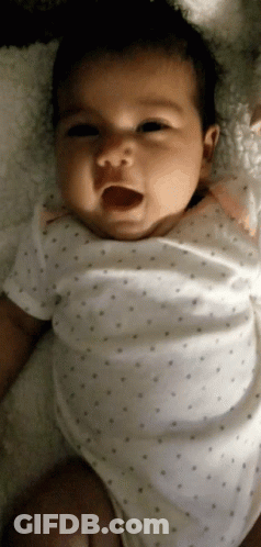 Baby In White Polka Dot Shirt Laying On Blanket GIF