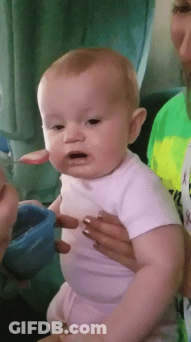 Baby In White Shirt Being Fed By Woman GIF